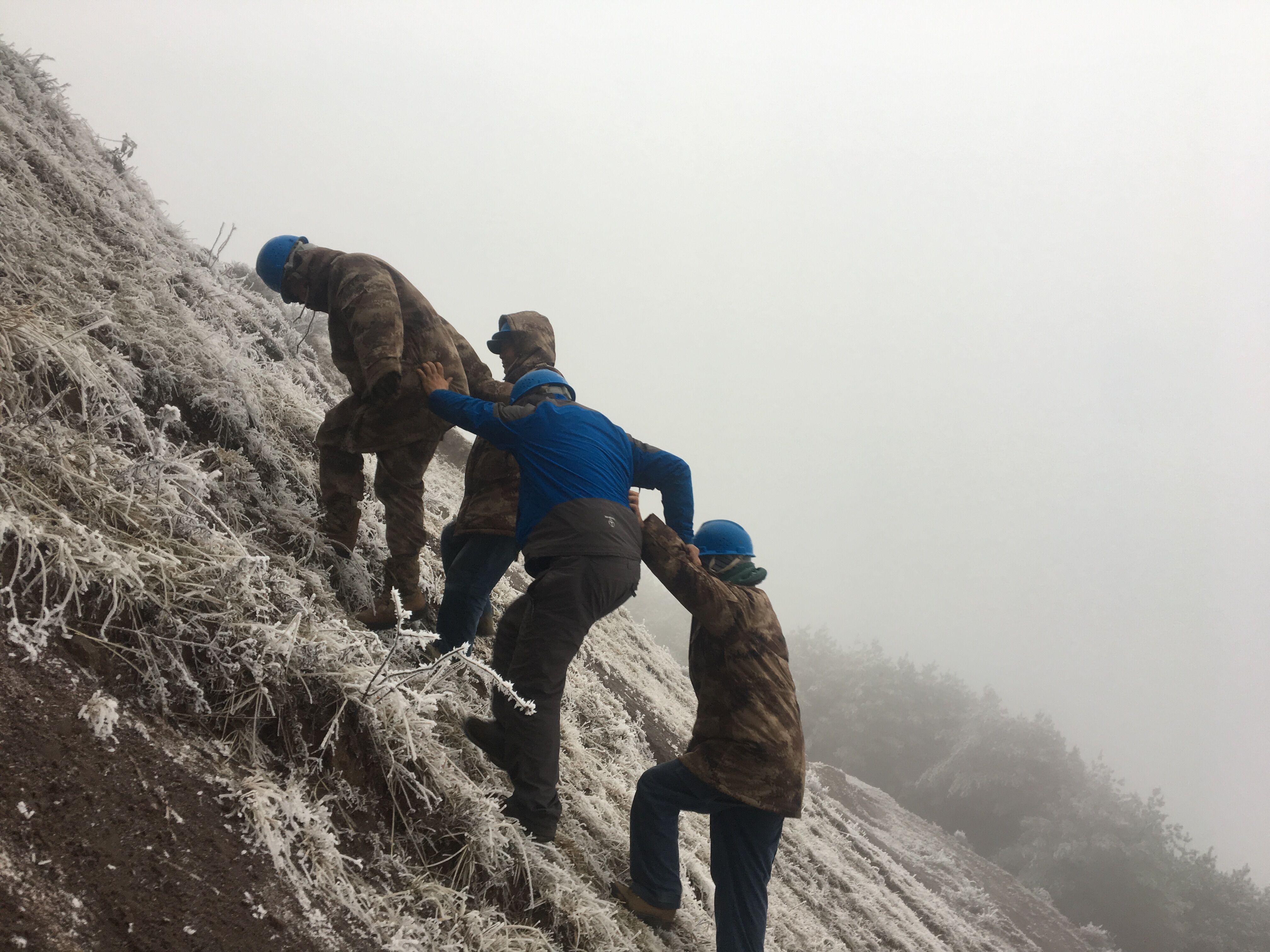 互相攙扶，勇登高峰。（李健攝）