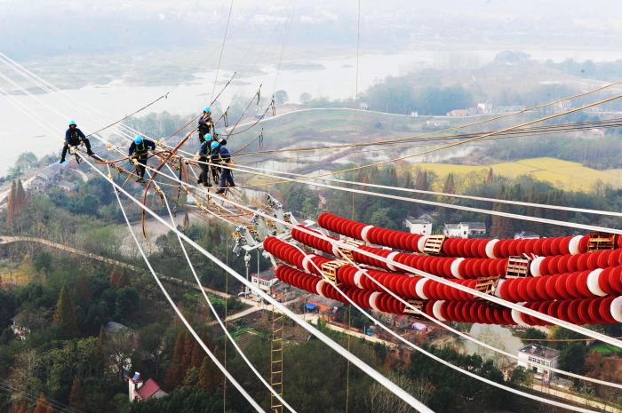 國(guó)網(wǎng)安徽電力施工人員在安徽蕪湖市南陵縣的80多米高空進(jìn)行導(dǎo)線附件安裝施工。（鄭賢列攝）